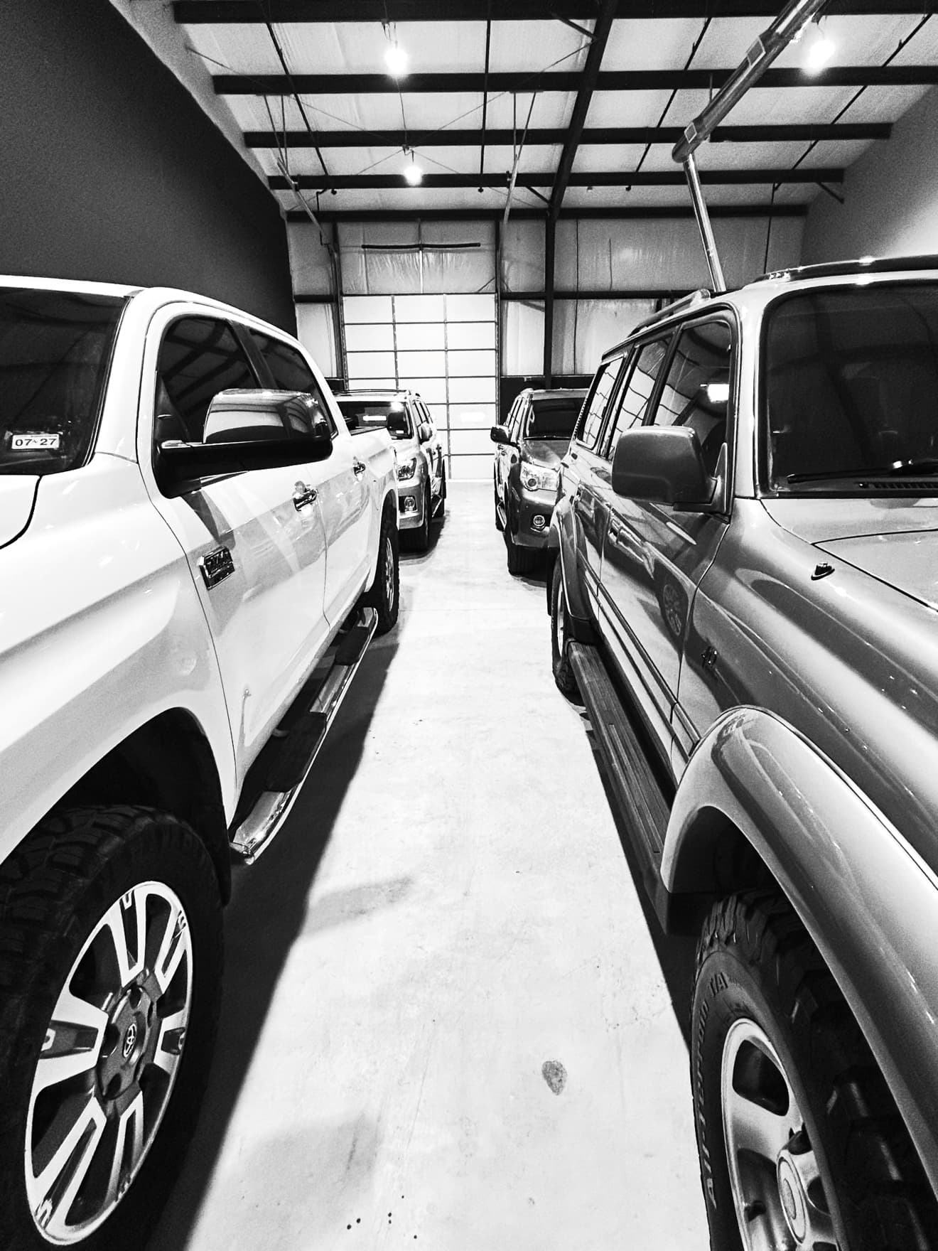 Black-and-white photo of Toyota trucks lined up inside the 407 Motors shop