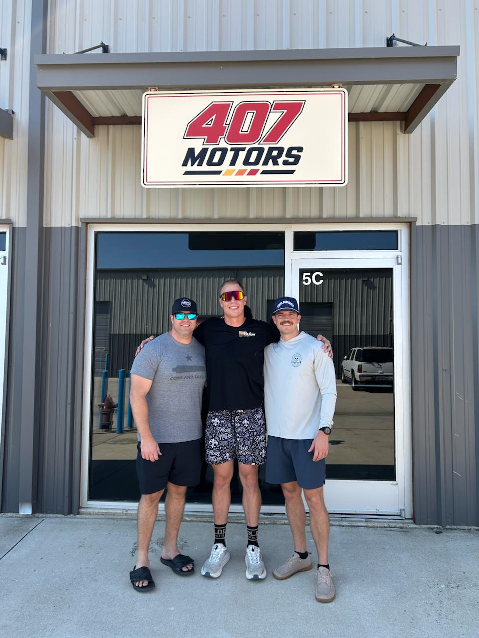 The three 407 Motors co-founders outside their Argyle shop beneath the 407 Motors sign